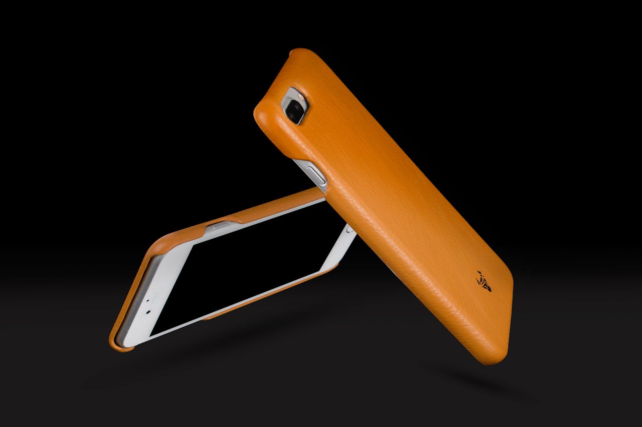 services-01 Dynamic image of sleek orange phone cases in a minimalist style, emphasizing modern technology and design.